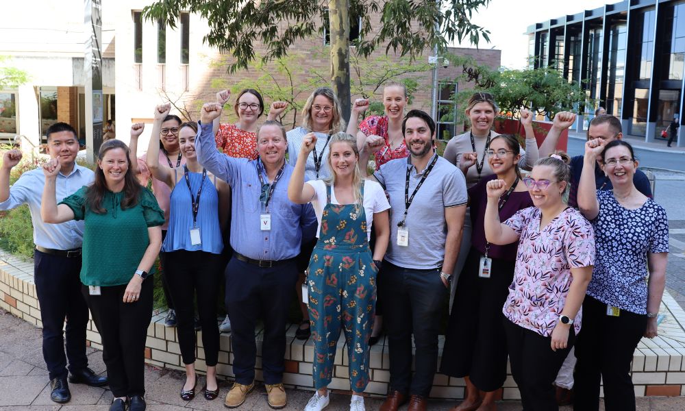 A group of HSUWA Members from PathWest Haematology stand together, smiling with their right fists raised.