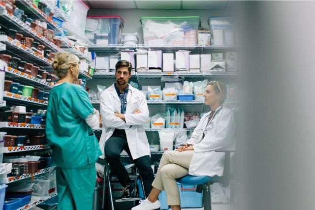 Health Professionals discuss details in a hospital pharmacy storeroom