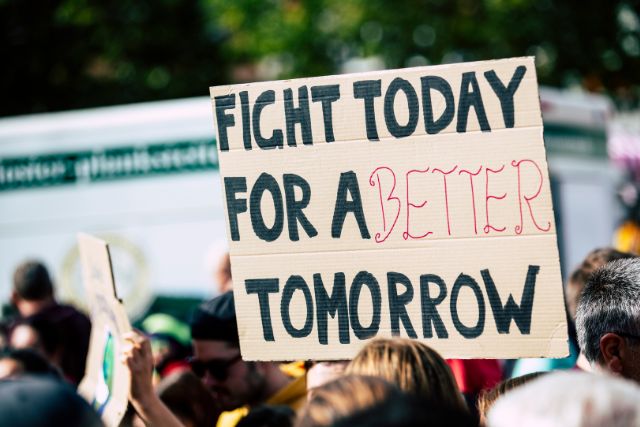 A close up of a cardboard sign at a rally. The sign says "Fight today for a better tomorrow".